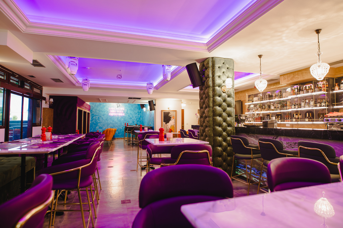 Prelijepi enterijer restoranskog bara u hotelu Integra u ljubičastim nijansama u vidu led rasvejete na krovu i stolica