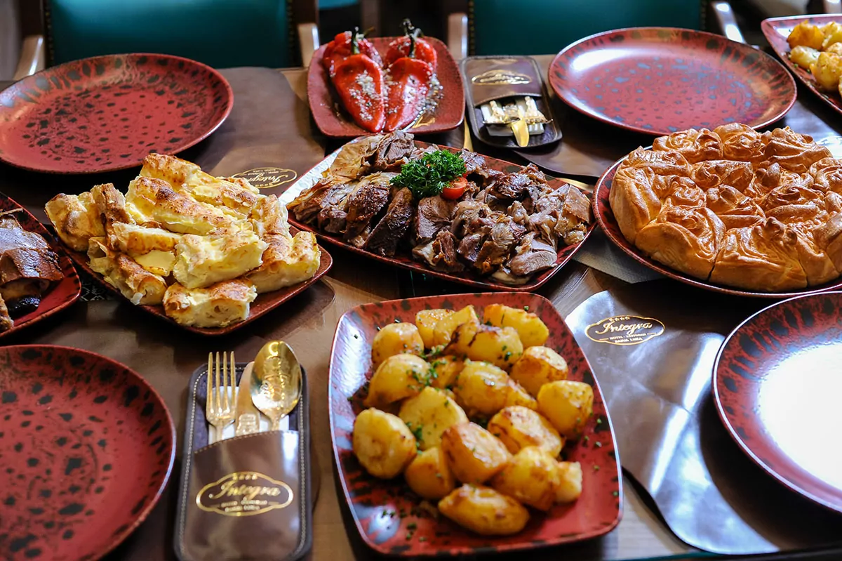 Domaća jela restoran Integra Raznovrsni domaći specijaliteti složeni na stolu u smeđim posudama u restoranu Integra